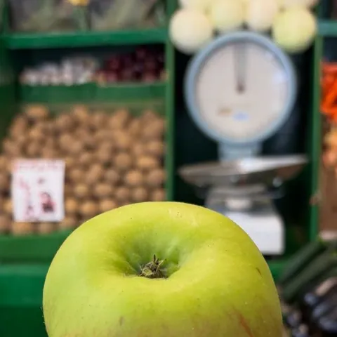 Bramley cooking apples on the scales at Parade Fruiterers, West Ealing